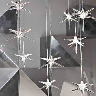 Elegant Reflex Stella suspension lamp with multiple transparent Pyrex glass star pendants and glossy silver-toned wires