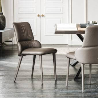 Distinguished Cattelan Italia Ginger chair upholstered in soft brown leather with slender steel legs and curved silhouette