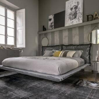 Elegant Arketipo Auto-Reverse Dream bed with muted gray textile and darker gray textured headboard crafted in leather or synthetic material