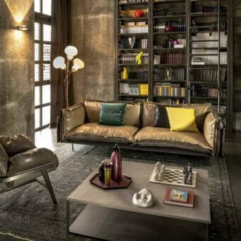 Distinctive Arketipo Auto-Reverse sofa with two-sided cover in textured gold-brown leather and deep teal fabric, highlighted by a prominent zip detail