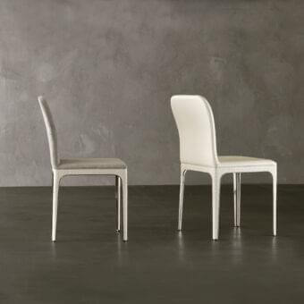 Distinguished Rugiano Viviane chair with curved backrest and polished metal legs upholstered in light neutral fabric exhibiting subtle texture