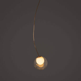 Distinguished Bocci 28 single suspension lamp with gracefully curved form in clear glass and natural copper exhibiting evolving patina