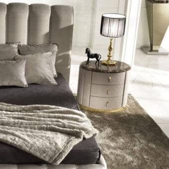 Elegant DV Home Collection Vogue nightstand with rounded form, light gray finish and marble-like surface crafted in MDF with gold metallic trim