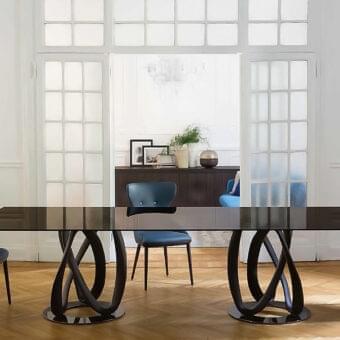 Distinguished Porada Infinity table with clear tempered glass and sculptural intertwined Canaletto walnut with chrome-plated metal rings