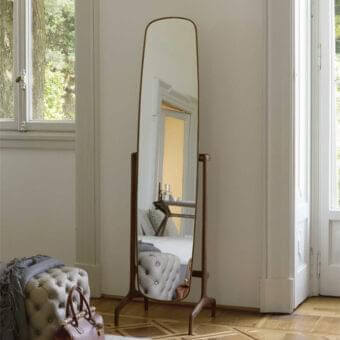 Distinguished Porada Timothy mirror with gracefully curved form and solid canaletto walnut in dark brown stain with brushed bronze brass accents