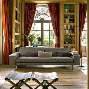 Superior Verzelloni Irving sofa upholstered in textured neutral gray textile with bronzed painted aluminium bridge feet and contrasting cushions