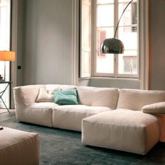 Distinguished Verzelloni Noe sectional with matte off-white textile upholstery and contrasting teal cushion built on lacquered beech feet