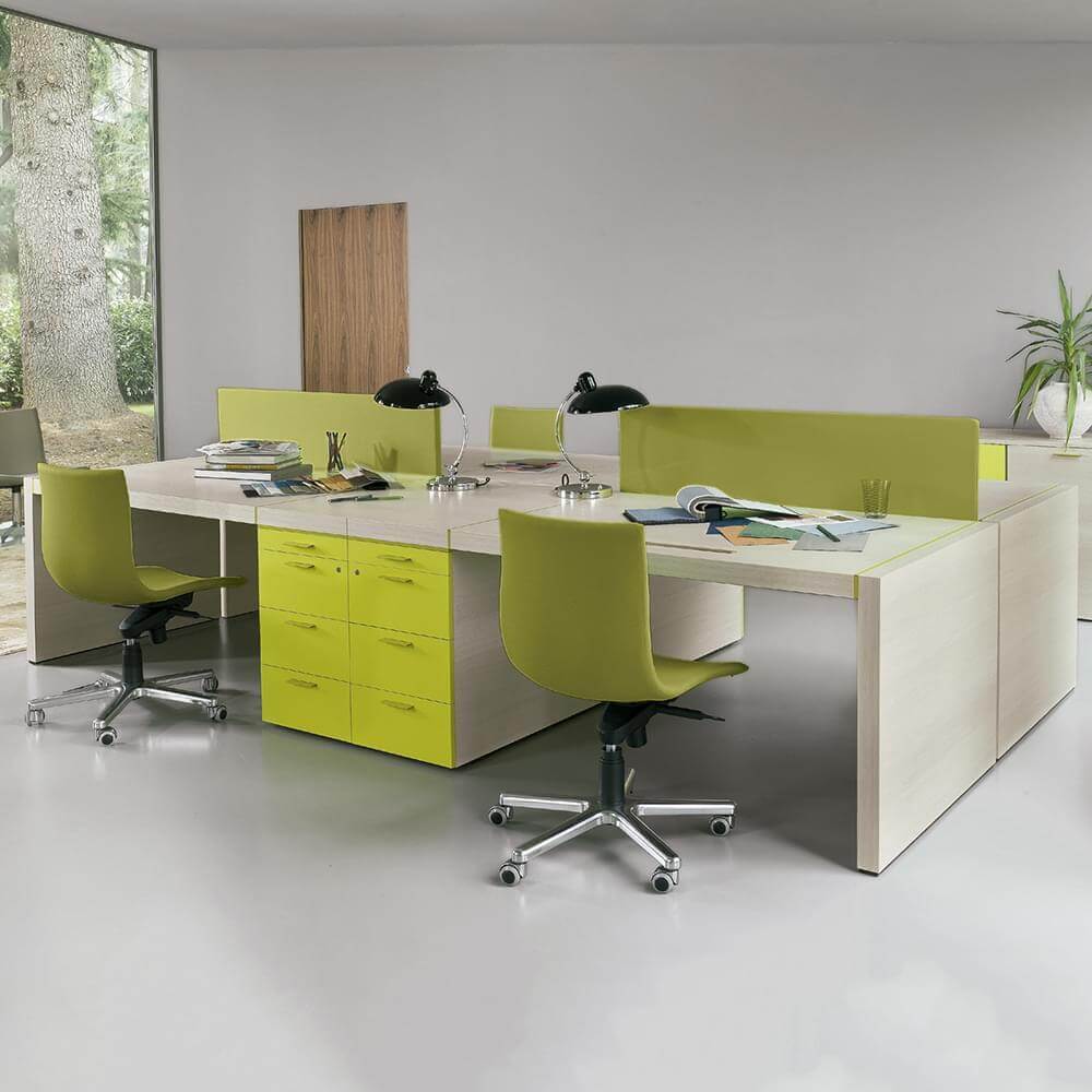Office workstation with light wood laminate desks, lime green acoustic panels, and ergonomic chairs, in a minimalist interior with wooded view.