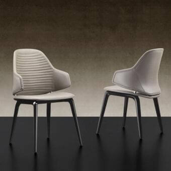 Superior Reflex Vela chair with sculpted resin shell, quilted backrest and smooth light beige upholstery supported by dark matte metal legs