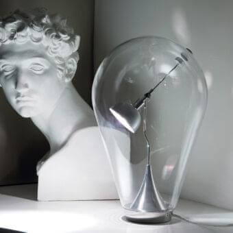 Distinctive Lodes Blow table lamp with clear blown glass enclosure and metallic spotlight head supported by a curved arm