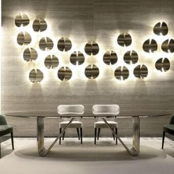 Elegant Rugiano Alyson table with clear glass top and wave-like light gold metal base crafted with skilled welding