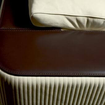 Exceptional Rugiano Vogue sofa upholstered in light cream ribbed synthetic material with dark brown glossy leather and bronze finish