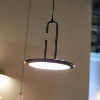 Elegant Penta Clip suspension lamp with dark metal structure and circular light framed in sleek finish