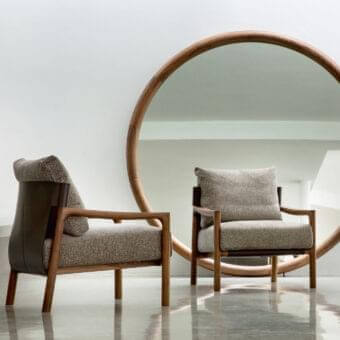 Sophisticated Porada Vera lounge chair with Canaletto walnut, Cuoietto leather accents and textured neutral gray fabric upholstery in satin finish