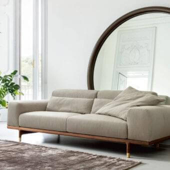 Elegant Porada Argo sofa with light beige textile upholstery and solid Canaletto walnut crafted with Brushed Brass feet