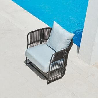 Distinguished Varaschin Tibidabo lounge chair with light blue cushion and dark-toned woven rope creating a striking chromatic contrast