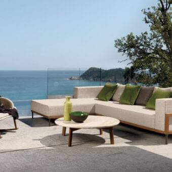Superior Talenti Cleo sectional with a geometric teak frame and light beige weather-resistant fabric cushions accented with green and brown