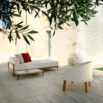 Distinguished Talenti Cleo lounger with light-colored weather-resistant fabric cushions and a matte teak frame