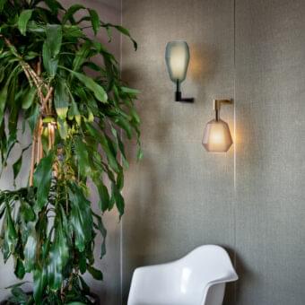 Distinguished Penta MoM wall lamp with a short brass-colored metal arm securing a polygon shade crafted from frosted amber borosilicate glass