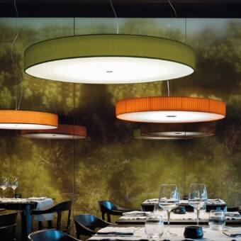 Elegant Modo Luce Discovolante suspension lamp with a textured fabric exterior in vibrant green and white illumination