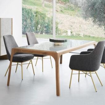 Distinguished Presotto Relevè table with sculpted light-toned wood legs and a smooth glossy clear glass tabletop
