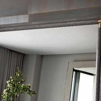Refined Rugiano Boheme mirror with bronze metal structure and medium gray woven textile covering, accented with gold-colored fittings