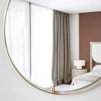 Distinctive Rugiano Ofelia mirror with teardrop silhouette crafted in metal with bronze finish and glossy brass accents