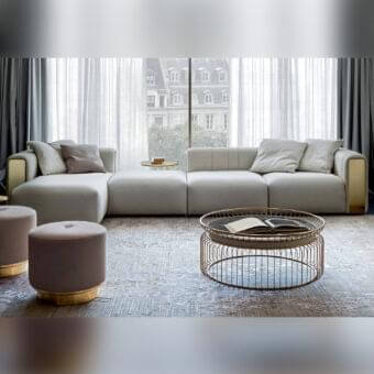 Elegant Rugiano Luz sectional with brushed brass detailing and harmonious plissé upholstered in light neutral gray textile with smooth matte finish
