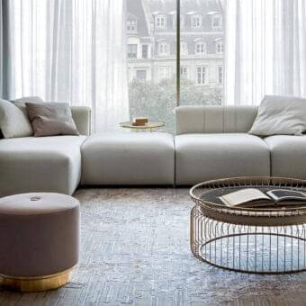 Distinguished Rugiano Luz sectional upholstered in light gray textile with matte finish and refined brushed brass detailing