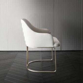Refined Rugiano Marie armchair with curved silhouette upholstered in off-white textile and bronze metal base
