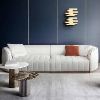 Lavish Rugiano Pierre sofa with light beige upholstery, bronze metal base and polished golden accents