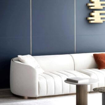 Exceptional Rugiano Pierre sofa with bronze metal base and off-white upholstery exhibiting smooth finish with vertical stitching