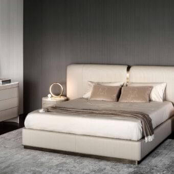 Distinguished Rugiano Vogue bed with light beige textile upholstery and a smooth finish, built with a refined bronze metal base