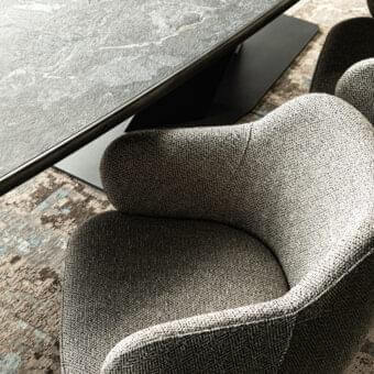 Sophisticated Cattelan Italia Bombè armchair upholstered in textured gray fabric with black embossed lacquered steel base