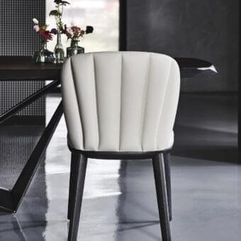 Distinguished Cattelan Italia Chrishell chair with curved silhouette upholstered in white synthetic leather and open pore matt black ashwood base