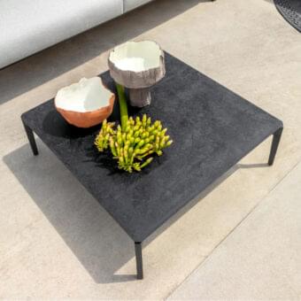 Innovative Talenti Leaf coffee table with aluminum base and vitter top in a dark gray textured finish