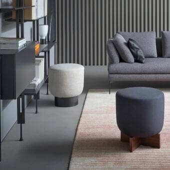 Elegant Bonaldo Belt & Cross ottoman with floating padded top and matte finish cross-shaped wooden base upholstered in dark gray textile
