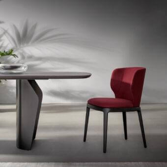 Elegant Bonaldo Joy chair with enveloping seat and backrest in deep red textile and dark-toned wood legs