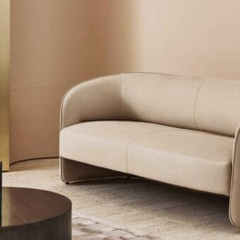 Elegant Rugiano Ambra sofa with refined curved silhouette upholstered in smooth beige high-end fabric