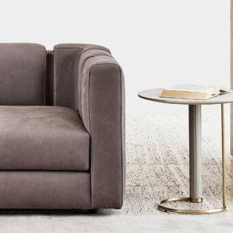 Elegant Rugiano Opale side table with cylindrical medium gray textured leather leg and brushed brass base supporting a matte light gray marble top