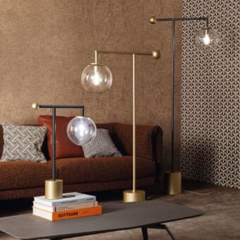 Distinguished Bonaldo Bardot table lamp with a geometric metal structure and transparent glass globe, in matte black with a glossy golden base