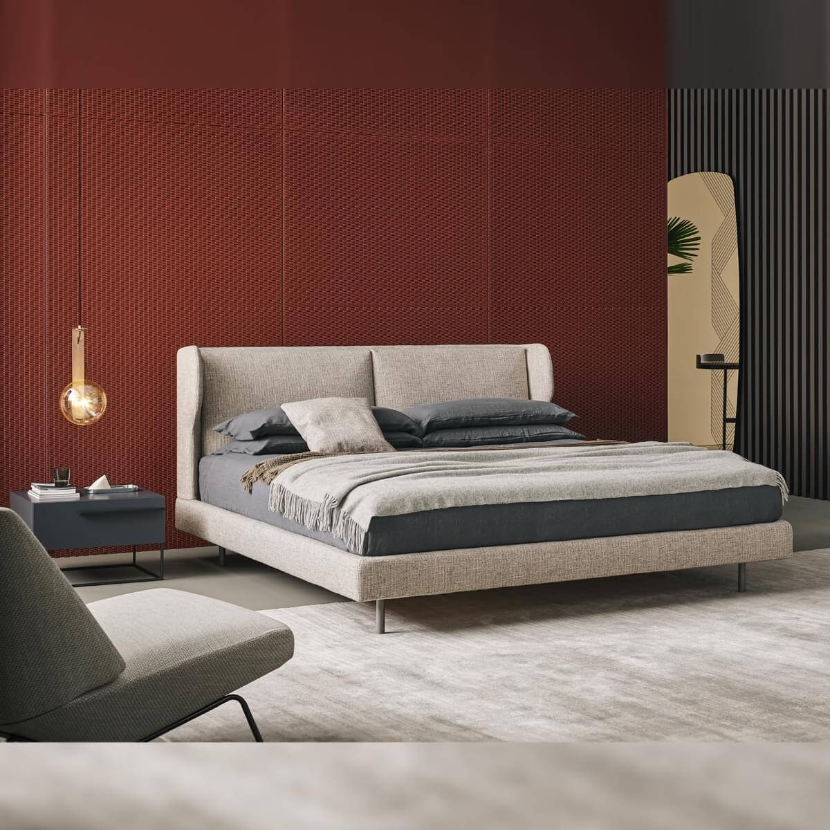 King bed, light gray upholstery, rectangular headboard in a modern bedroom with terracotta wall, gray accents, and amber glass lamp.
