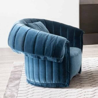 Exceptional Rugiano Manta lounge chair upholstered in deep teal blue textured textile with elegantly curved backrest and rounded arms
