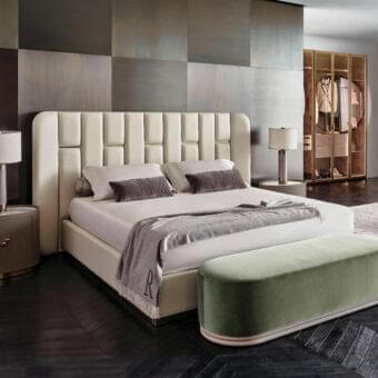 Superior Rugiano Victoria bed with a geometric padded headboard and lustrous brass details in light cream textile upholstery