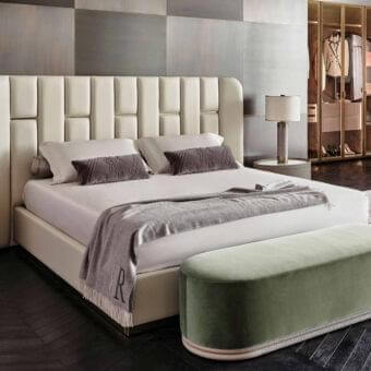 Superior Rugiano Victoria bed with light cream textile upholstery, vertical paneling and brass detailing crafted in Italy