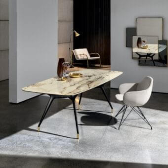 Refined Sovet Italia Arkos table with a marbled cream, beige, and brown top and matte black structural X legs