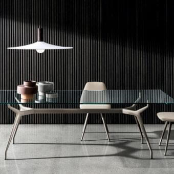 Cutting-edge Sovet Italia Arkos table with a sleek glass top and matte gray die-cast aluminum X-shaped legs