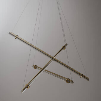 Brass suspension lamp with four intersecting cylindrical rods, neutral gray backdrop, minimalist design, circular connectors, studio lighting.