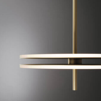 Soul Suspension Lamp, brushed brass, two circular diffusers aligned with vertical rod, minimalist geometric design.