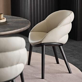Sophisticated Cattelan Italia Camilla armchair with enveloping curves and smooth light beige synthetic leather upholstery